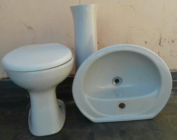 Conjunto de banheiro com vaso sanitário e pia com coluna