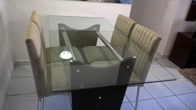 Mesa com quatro cadeiras e tampo de vidro