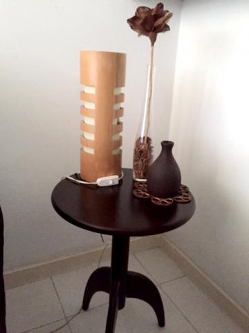 Mesa de canto com abajur e objetos de decoração