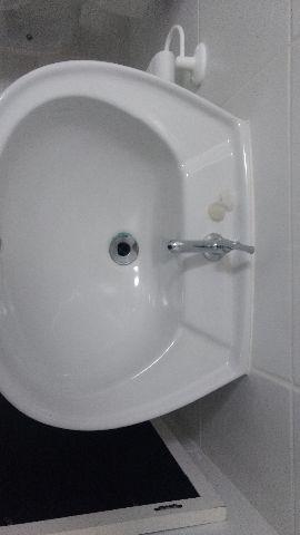 Arara de roupa e pia de banheiro com coluna