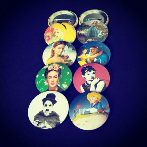 Buttons: Personagens (Frida, Chaplin, Alice, Bela.)
