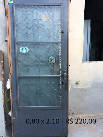 Porta de ferro com janela e grades diversas