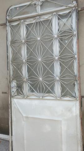 Porta de ferro com os vidros e uma janela