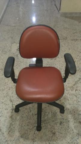 Uma cadeira com rodinhas e braços bem conservada